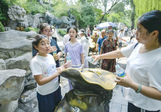 泉涌旺盛带火泉水游，游客争相品尝泉水享清凉