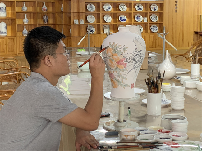 师傅正在对钙质瓷进行手绘艺术创作。谈媛摄